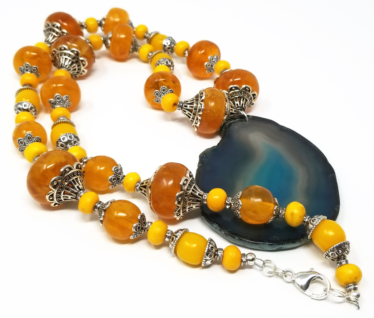 African Amber and yellow wood beaded necklace with a blue agate pendant