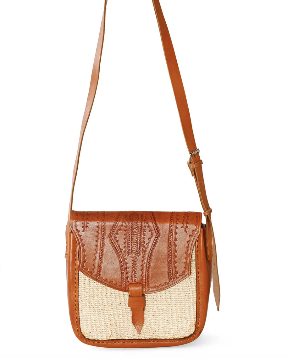 A brown leather and woven sisal crossbody bag with a long shoulder strap, photographed against a plain white background.
